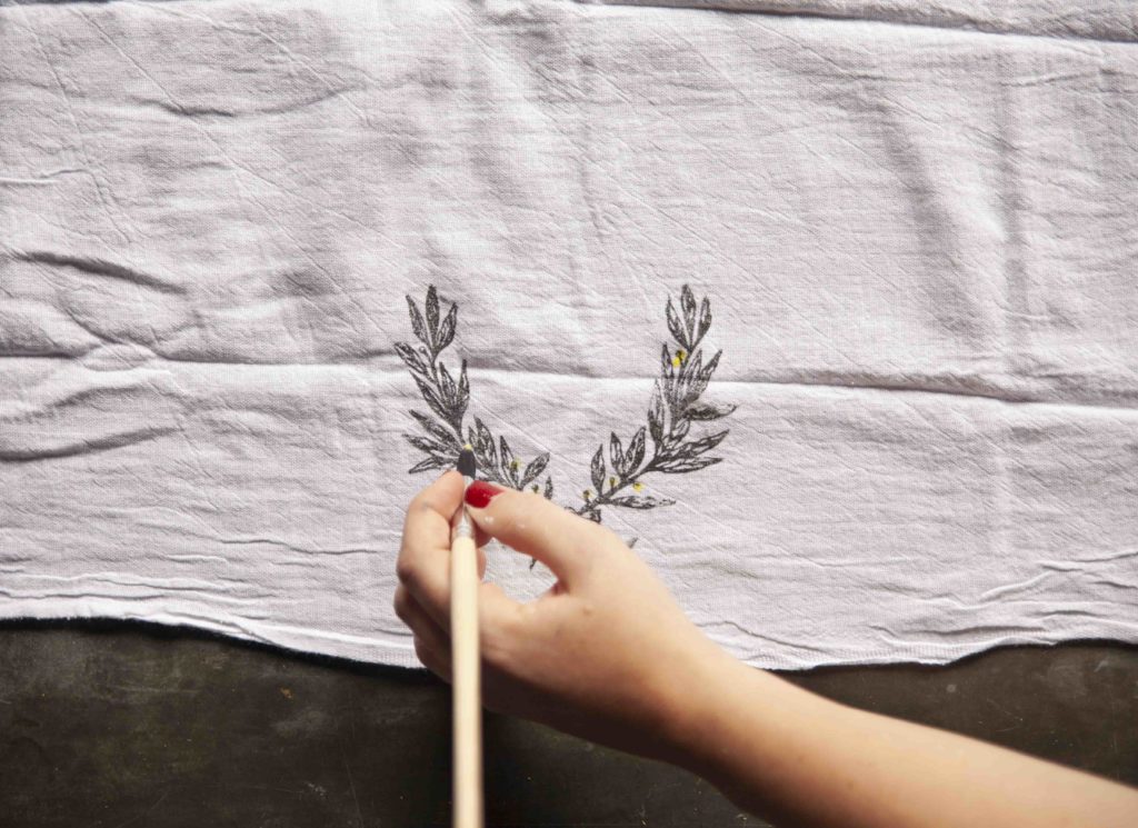 Design and paint your own watercolor tea towel using A Makers’ Studio stamps and Gel Art Ink. Make a beautiful laurel, floral tea towel for your kitchen or bathroom!